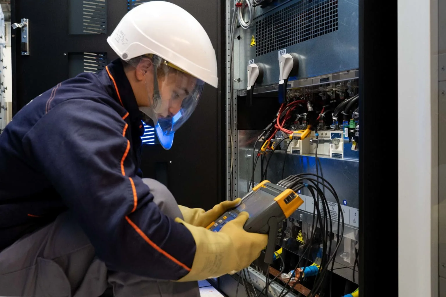 Technicien effectuant la maintenance d’un onduleur hospitalier