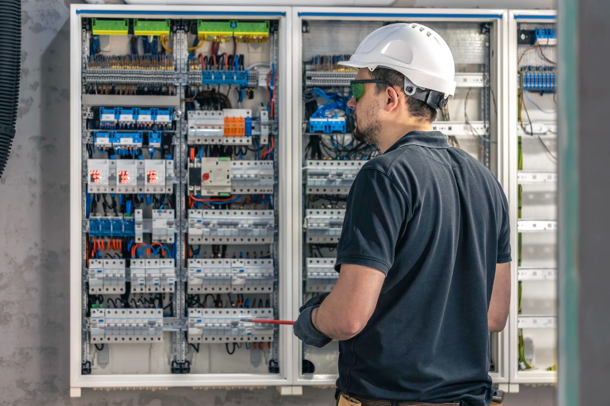 main d'électricien vérifiant ou testant un tableau électrique résidentiel